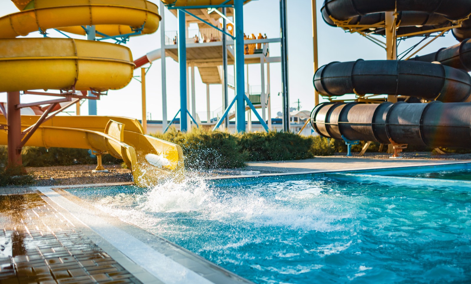 Mujer llegando a la piscina desde un tobogán