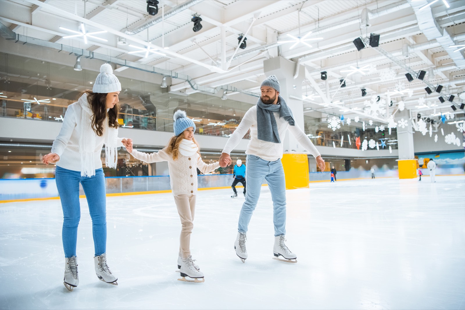 Familia patinando en una pista de hielo iluminada
